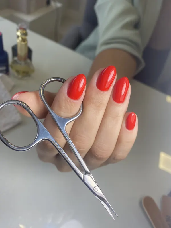 Detalhe aproximado de unhas amendoadas em vermelho vivo