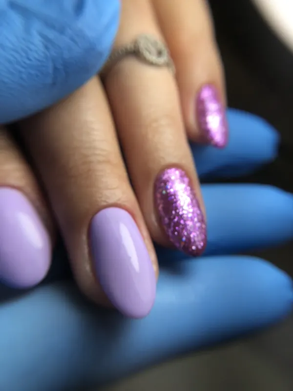 Unhas amendoadas em lilás com uma unha em glitter rosa